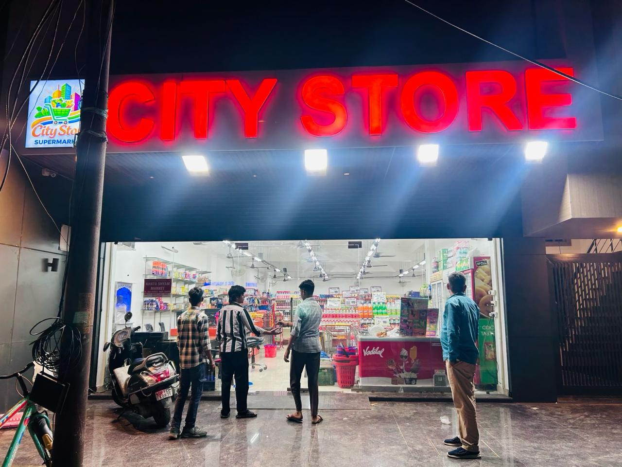 City Store Supermarket storefront in Meerut at night with bright neon signage